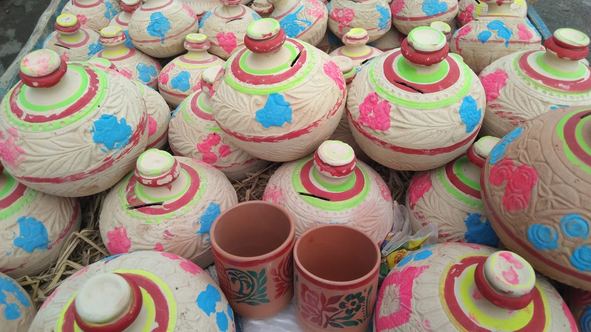 Hand-painted clay pots and cups at a market