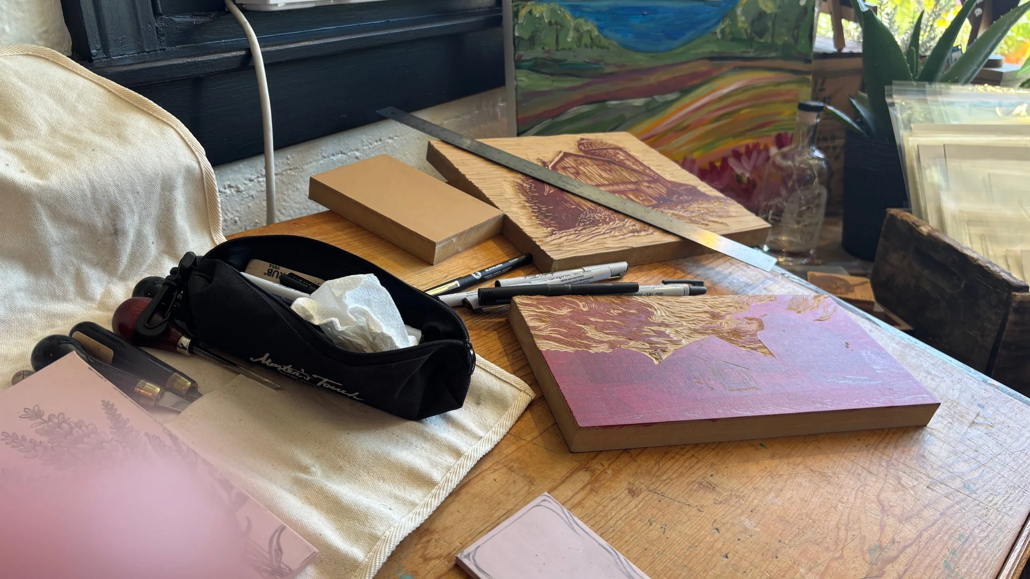 Carved lino blocks and cutting tools on a worktable